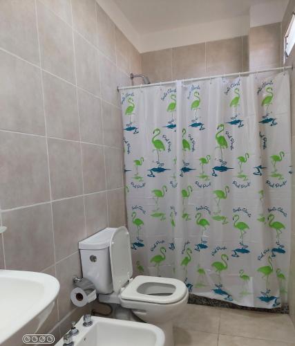y baño con aseo y cortina de ducha. en DUPLEX 2 en San Fernando del Valle de Catamarca