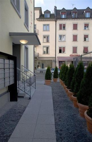 a row of potted trees inront of a building at The Henry Self Check-In Guesthouse in Zürich