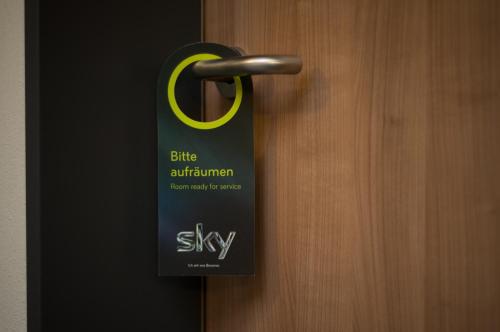 a black doorhandle with a black and yellow sign on it at Park-Hotel Leimen in Leimen