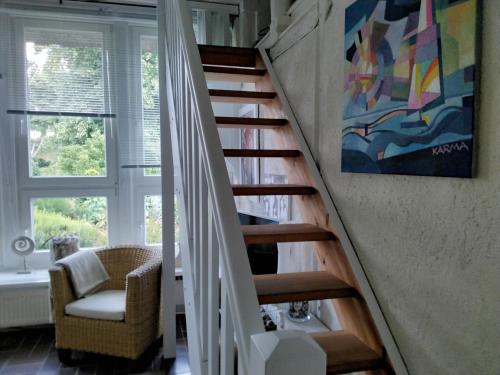 una escalera en una habitación con una silla y una pintura en Ferienatelier 2, en Steffenshagen