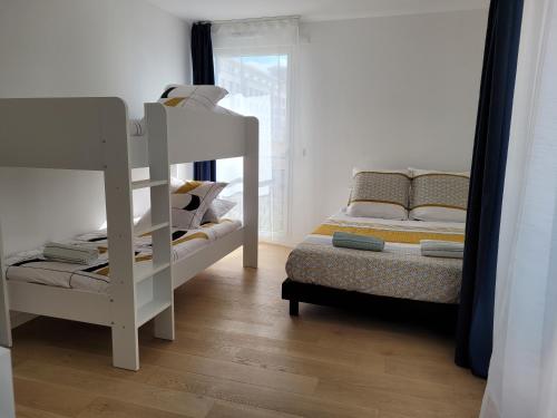 1 Schlafzimmer mit 2 Etagenbetten neben einem Fenster in der Unterkunft Chez Patron T3 2BR with 2 parking near Disneyland Paris & train station-Chessy in Chessy