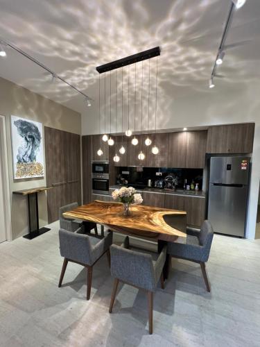 a kitchen with a wooden table and some chairs at By The Sea Beachfront Designer Suites Penang - Managed by Art of Tree in Batu Ferringhi