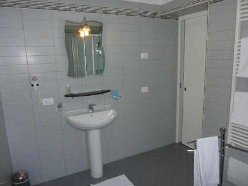 a white bathroom with a sink and a mirror at Alla Bianca Hotel in Marghera