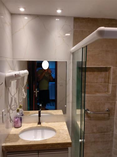 a person taking a picture of a bathroom with a sink at Gravatá Winterville Residence in Gravatá