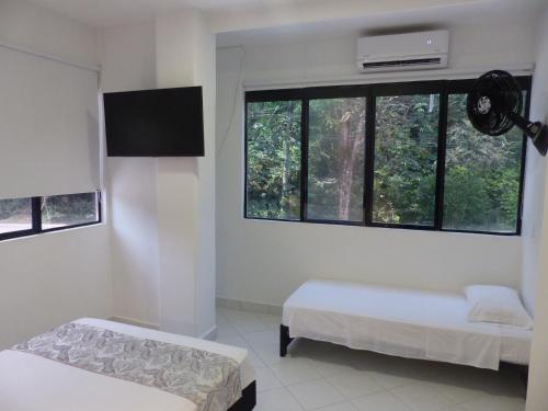 a room with two beds and a window at Campo Godoy in Doradal