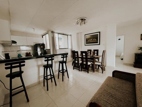 cocina y sala de estar con encimera y taburetes en Apartamentos Vacacional Cartagena cerca Aeropuerto y Playa, en Cartagena de Indias