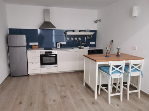 a kitchen with white cabinets and a wooden table and chairs at Nostalgia apts in Limassol
