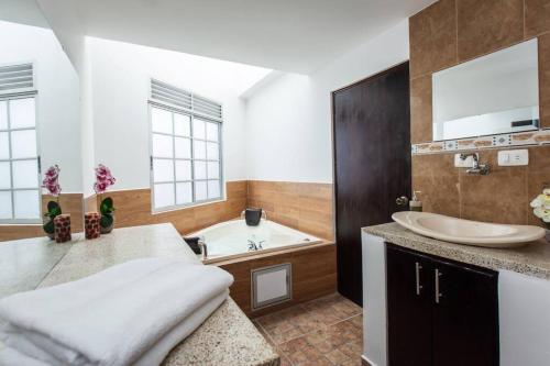 y baño con bañera y lavamanos. en Cozy 4 Bedroom Home with Jacuzzi and Outside Deck, en Armenia
