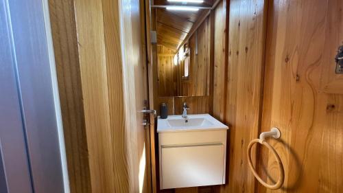 La petite salle de bains est pourvue d'un lavabo et d'un miroir. dans l'établissement Suspended Wooden House - Monte da Cortiça, à Águas de Moura