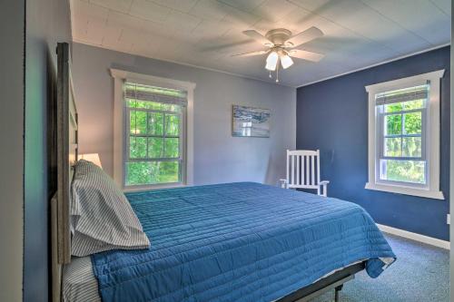 um quarto azul com uma cama e 2 janelas em Peaceful Finger Lakes Apartment with Patio! em Ovid