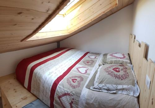 Bett in einem kleinen Zimmer mit Fenster in der Unterkunft Studio Ptilou B36 2/4 pers. avec vue in Le Dévoluy