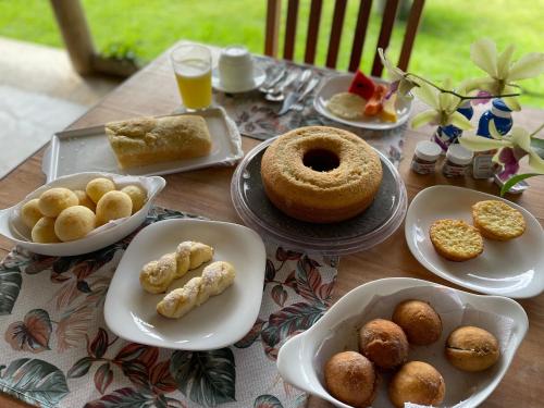 a table with plates of pastries and donuts on it at Pousada Casa Caju Bangalows in Cumbuco