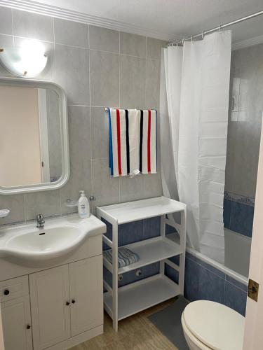 a bathroom with a sink and a toilet and a mirror at Aquamarine home in Campoamor