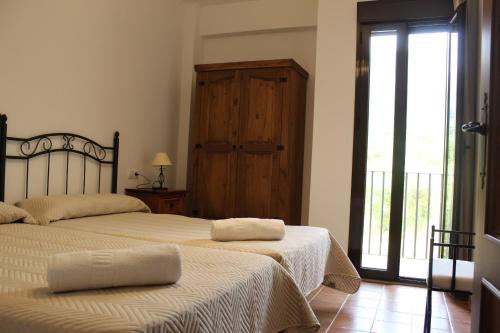 1 dormitorio con 2 camas y puerta corredera de cristal en Casa Marta by CasaTuristica, en Jimera de Líbar