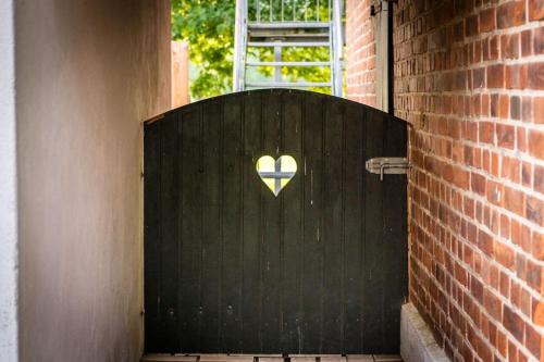ein schwarzes Tor, auf dem ein Herz gemalt ist. in der Unterkunft Traumferienwohnung in der Lüneburger Heide in Soltau