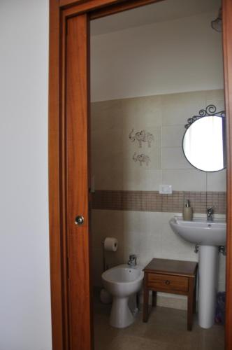 a bathroom with a sink and a toilet and a mirror at Sisters house in Lecce