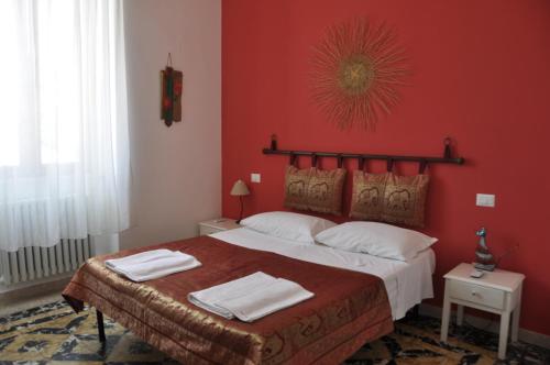 a bedroom with a large bed with red walls at Sisters house in Lecce