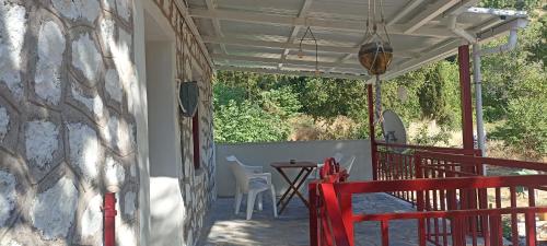 eine Veranda eines Hauses mit einem Tisch und Stühlen in der Unterkunft Kanitsis House in Drymon