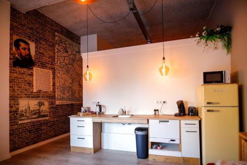a kitchen with a sink and a refrigerator at Bed & Breakfast Bakker Meijer in Heemskerk