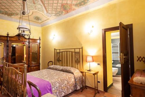 ein Schlafzimmer mit einem Bett und ein Badezimmer mit einer Badewanne in der Unterkunft Degli Alessandri Palace in Sassoferrato