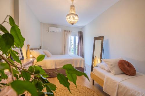 1 dormitorio con 2 camas, espejo y sofá en Attico blu - Sea View Penthouse, en Cos