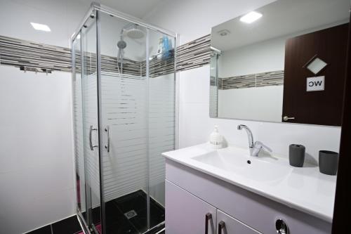 a bathroom with a sink and a glass shower at The desert Pearl in Eilat