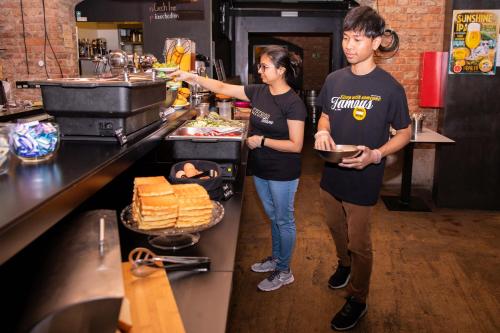 two people standing in a kitchen preparing food at Czech Inn in Prague