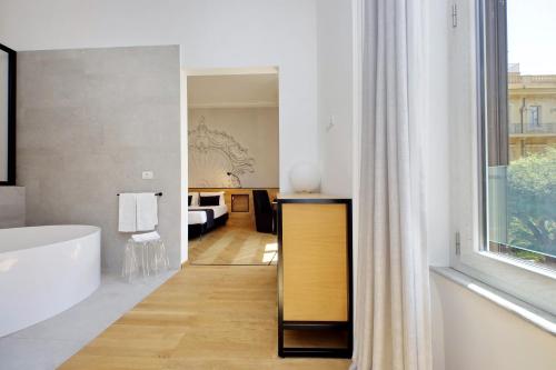 1 dormitorio y baño con bañera. en Youroom Abruzzi, en Roma