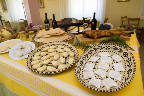 a table with plates of food and bottles of wine at Hotel Grillo in Nuoro