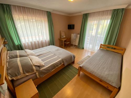 a bedroom with a bed and a chair in it at Villa Lux in Hévíz