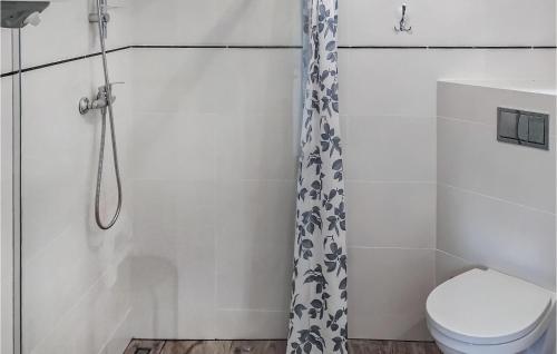 La salle de bains est pourvue d'un rideau de douche et de toilettes. dans l'établissement Lovely Home In Choczewo With Kitchenette, à Słajszewo