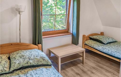 Cette petite chambre comprend 2 lits et une fenêtre. dans l'établissement Lovely Home In Choczewo With Kitchenette, à Słajszewo