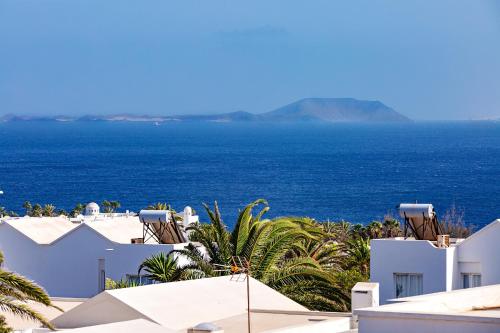 a view of the ocean from the roofs of white buildings at Sea Sky Lanzarote in Playa Blanca