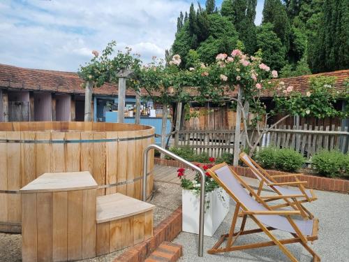 a patio with a chair and a pergola with roses at Great Fosters - Near Windsor in Egham
