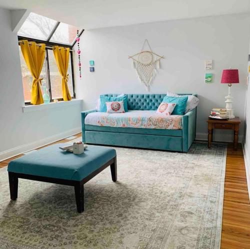 a living room with a blue couch and a table at A Regal Retreat- Exclusive Parking, Prime Location in Philadelphia