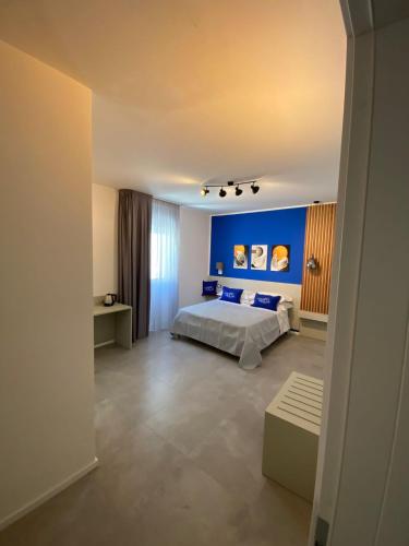 a bedroom with a bed and a blue wall at La Corte del Sole in Vieste