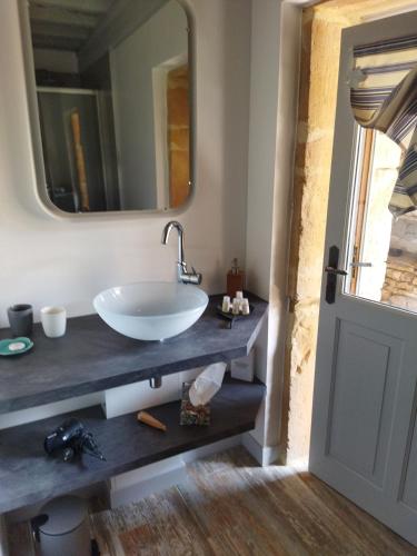 a bathroom with a sink and a mirror at La ferme du vincent in Liergues