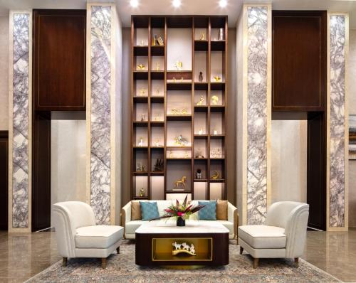 a lobby with two chairs and a table and a book shelf at Blossom Hotel Houston, Curio Collection by Hilton in Houston