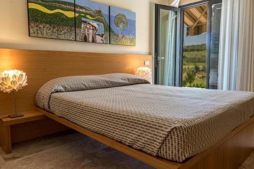 a bedroom with a bed and a large window at Hotel Poggio Bertino in Montemerano