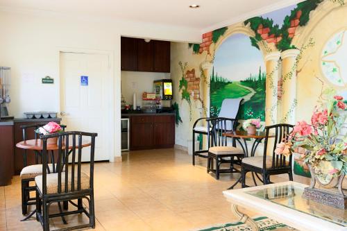 a kitchen with chairs and a table with a painting on the wall at The Symphony Inn & Suites in Houston