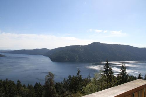 a view of a large body of water with mountains at Moon Water Lodge in Malahat