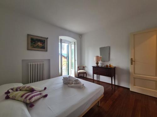 a white bedroom with a bed and a table and a mirror at Villa Draga by PortofinoVacanze in Santa Margherita Ligure