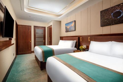 a hotel room with two beds and a flat screen tv at Blossom Hotel Houston, Curio Collection by Hilton in Houston