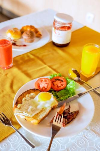 ein Frühstücksteller mit einem Ei und Tomaten in der Unterkunft Grazia Apartment Hotel in Kigali