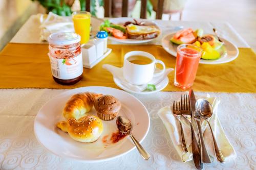 ein Tisch mit Tellern voller Frühstücksspeisen darauf in der Unterkunft Grazia Apartment Hotel in Kigali