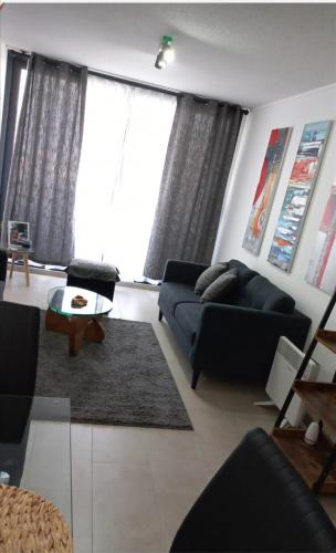 uma sala de estar com um sofá e uma mesa em Departamento Nuevo Premium Hospedaje Rancagua - Centro em Rancagua