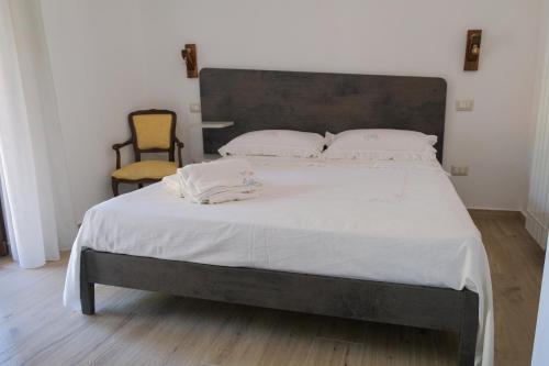 a bedroom with a large bed and a chair at Dimora Cice in SantʼAgata deʼ Goti