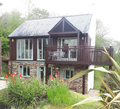 a house with a deck and a balcony at Sunningdale Lodge,St Mellion,Cornwall-FreeGolf&Spa in St. Mellion