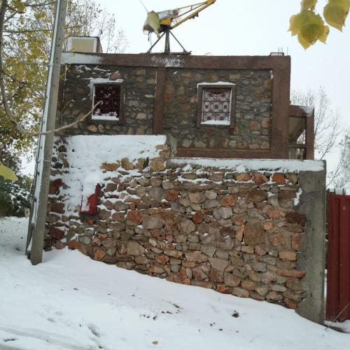 een stenen gebouw in de sneeuw met een vogel bovenop bij Villa Mlak dayat Aoua in Ifrane