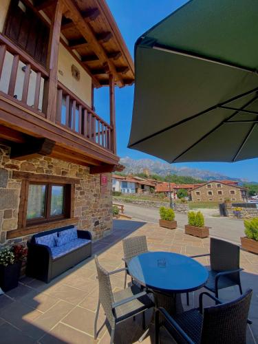 a patio with a table and chairs and a fireplace at Apartamentos La Ventana de Mogrovejo in Mogrovejo